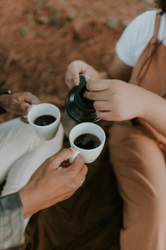 A couple enjoying coffee together outside, captured in a warm and relaxed setting.